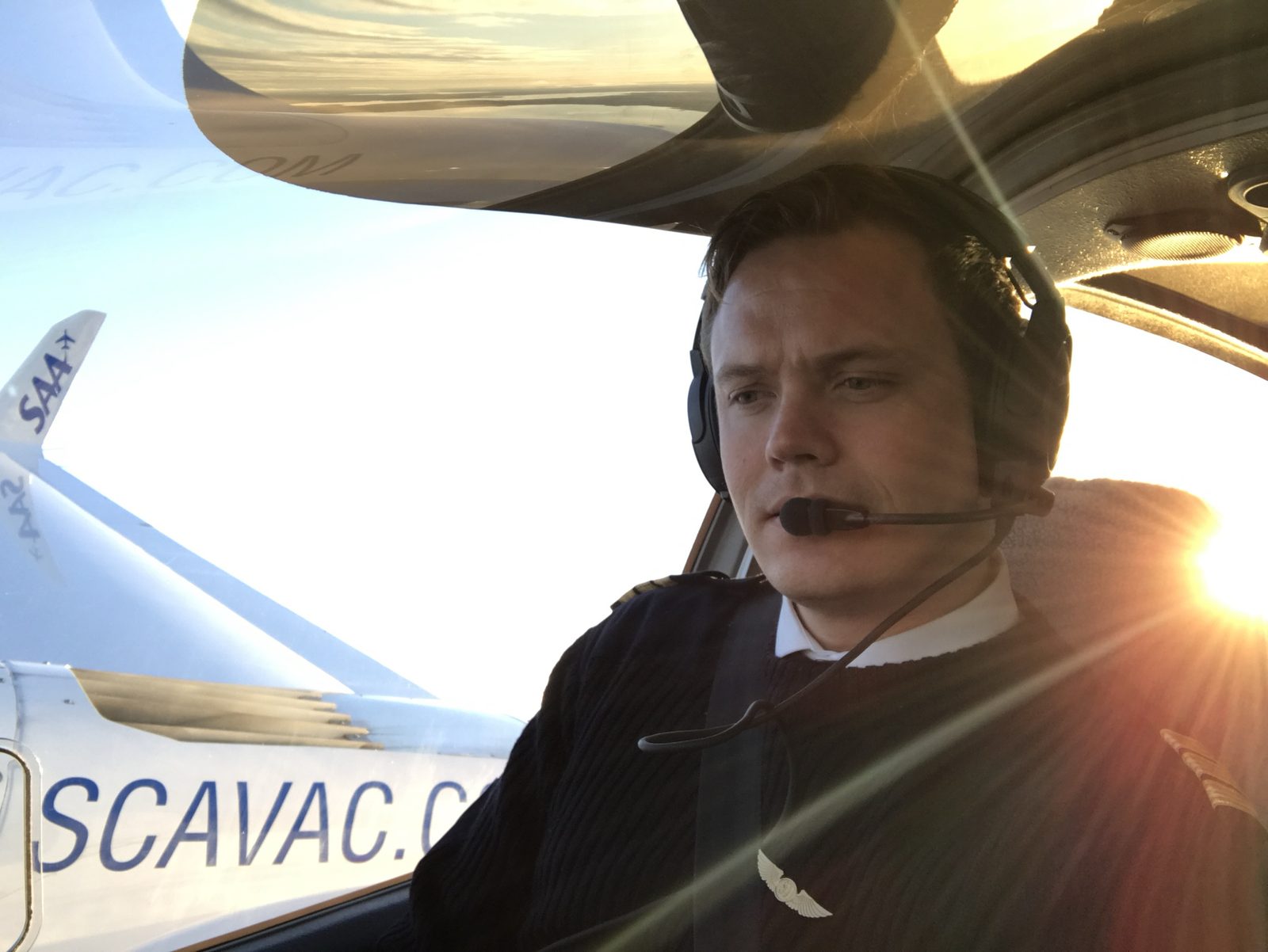Stein in uniform and headset, flying a training aircraft